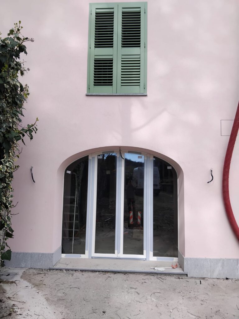 Ingresso ad arco con serramento vetrato e persiana superiore